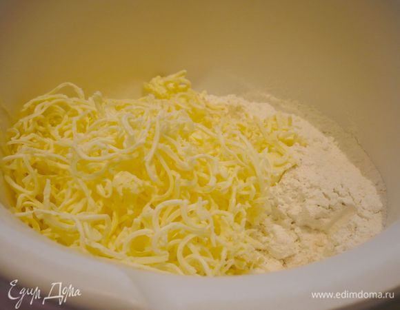 Смешиваем муку с щепоткой соли. Натираем масло, перемешиваем тесто до состояния крошки.