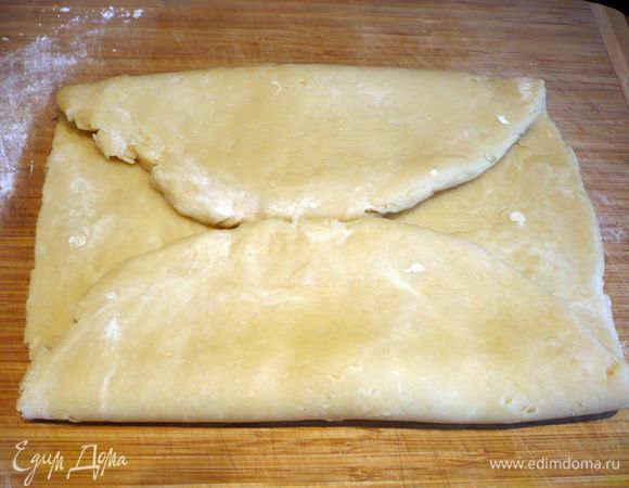 Раскатываем тесто на присыпанной мукой поверхности в прямоугольный пласт. Сворачиваем его, как показано на фото с двух сторон. 