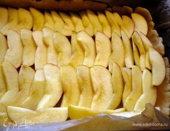 Тесто выкладываем в форму, образуя небольшие бортики. Яблоки выкладываем рядами, сверху кусочками выкладываем масло.