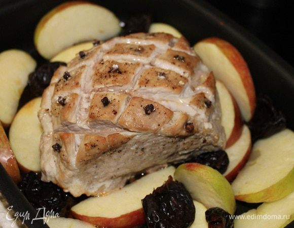 Чернослив замочить в теплой воде на 15 минут. Яблоки вымыть, удалить сердцевину и нарезать дольками. Вынимаем форму из духовки, выкладывает яблоки и чернослив вокруг мяса. Кусок мяса поливаем сверху медом и присыпаем сахарной пудрой, отправляем в духовку на 20 минут,через 10 минут переворачиваем дольки яблок.