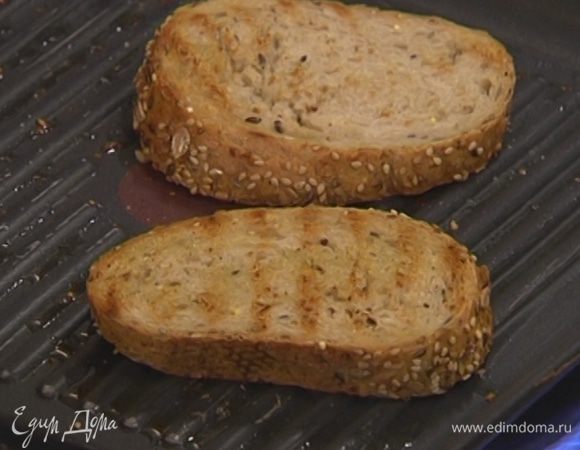 Разогреть в сковороде-гриль оливковое масло и обжарить хлеб с двух сторон.