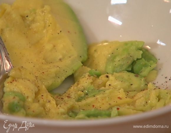 Мякоть авокадо вынуть ложкой, размять, сбрызнуть оставшимся лимонным соком, посолить, поперчить.