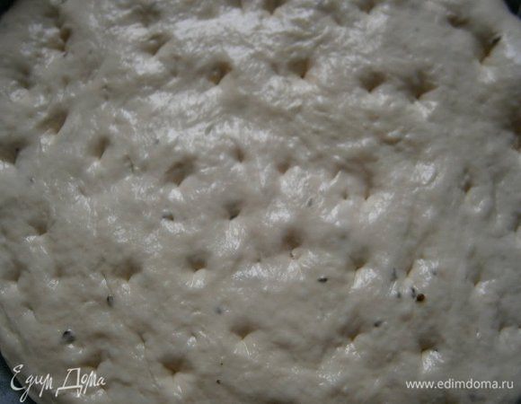 Форму застелить бумагой для выпечки и смазать оливковым маслом. Выложить тесто прямо из миски (ничего месить не нужно!) и растянуть тесто по форме, смазав руки оливковым маслом, сделать пальцами углубления. Накрыть плёнкой и дать расстояться 30 минут.