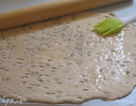 Каждую часть теста раскатать на присыпанной мукой поверхности в очень тонкий пласт. Смазать его небольшим количеством слегка взбитого белка.