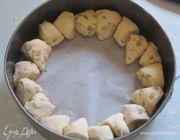 Форму для выпечки выстлать бумагой для выпечки, промазать маслом. Выложить по кругу получившиеся треугольники, оставляя между ними зазор в 2-3 мм. В центр выложить маленький шарик из теста.