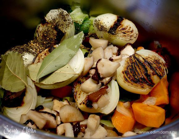 На сухой сковороде обжариваем лук в течение пары минут на стороне среза до темно-коричневого цвета. В кастрюлю опускаем овощи, лук, пряности, чеснок, порезанные грибы и томатную пасту с солью. Заливаем 2 литрами холодной воды и ставим вариться.