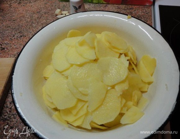 1.	Чеснок разрезать на половинки. Картофель очистить и нарезать тонкими ломтиками. Я использую терку для нарезки таких ломтиков.