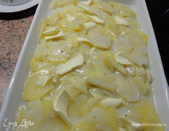 3.	Духовку включить для разогрева до 200 градусов. Форму для запекания натереть половинкой чеснока и смазать размягченным сливочным маслом (1/2 ст. ложки).
4.	Удалив чеснок из картофеля с молоком, аккуратно переложить его в подготовленную форму для запекания. Сверху выложить кусочки сливочного масла.