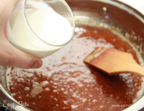 Постоянно помешивая, добавить сливки, вливая тонкой струйкой. Смесь начнёт пениться и увеличиваться в высоту. Продолжить размешивать смесь до гладкости. Дать карамельному соусу остыть в сотейнике в течение 10-15 минут.