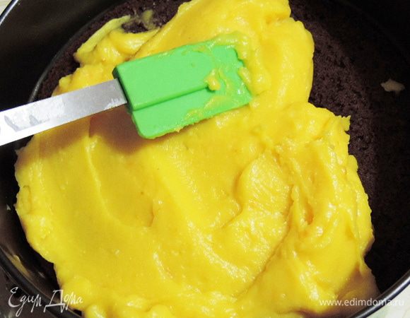 Выкладываем на блюдо один корж срезом верх. Заключаем его в кулинарное кольцо или кольцо от разъемной формы, в которой бисквит выпекался. Равномерно распределяем по бисквиту курд. Он может быть еще даже немного теплым. Накрываем сверху вторым бисквитным коржом, который кладем срезом вниз. Оставляем нашу заготовку при комнатной температуре и займемся муссом. 