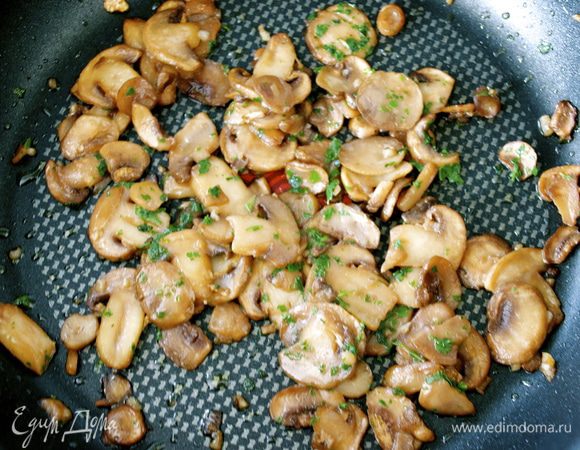 Грибы (шампиньоны) нарезать. Обжарить грибы и измельченный зубчик чеснока на сковороде в течение 5-7 минут. Добавить мелко нарезанную петрушку и тушить до тех пор, пока жидкость из грибов не выпарится.  