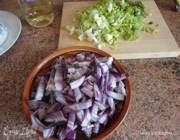 Красный лук мелко нарезать. Так же нарезать лук порей вместе с зеленой частью (можно и без лука порея).
В сковороде или кастрюле с толстым дном разогреть растительное масло вместе с оливковым, выложить красный лук и лук порей и жарить на медленном огне постоянно помешивая 25 минут, пока лук не станет золотистым и начнет карамелизоваться.
