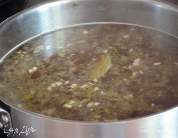 Добавить измельченный чеснок, листики тимьяна (или ½ ч.л. сухого), влить вино, бульон, дать закипеть, уменьшить огонь, накрыть крышкой и готовить 25 минут. В конце добавить лавровый лист, перец, соль.