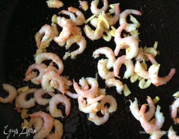 На разогретом оливковом масле обжарить порубленный чеснок. Добавить к нему креветки и обжаривать их в течение минуты.