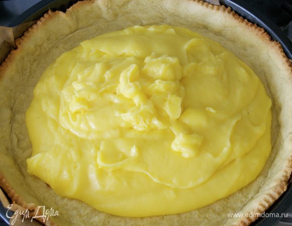 К тому времени основание тарта испеклось... Достать форму из духовки, понизить температуру до 180 С. Удалить бумагу с фасолью и выложить полученный крем. Разровнять...