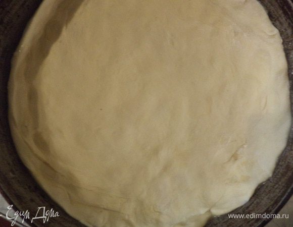 Размороженное слоёное тесто раскатать, выстелить им форму, смазанную маслом, сделав высокие бортики.