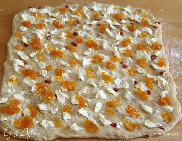 Тесто выложить на слегка присыпанный мукой стол, сформировать руками квадрат (у меня 40х40 см). Выложить начинку: масло и джем.