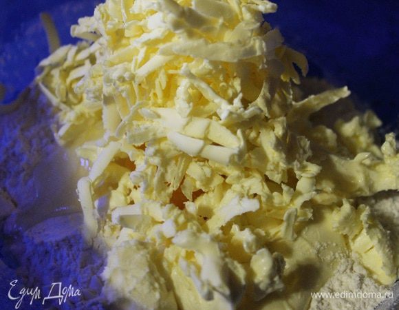 В глубокую миску просеять муку, добавить яйцо, соль и потертое на терке холодное масло. Перемешать все рукой до состояния мелкой крошки.