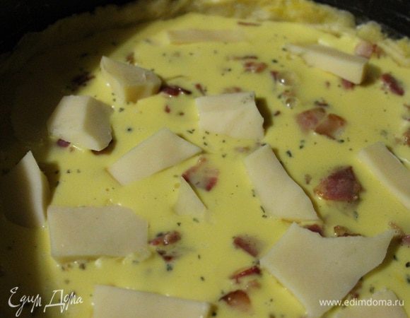 И вылить в форму на тесто с беконом. Сыр нарезать пластинками и выложить сверху.