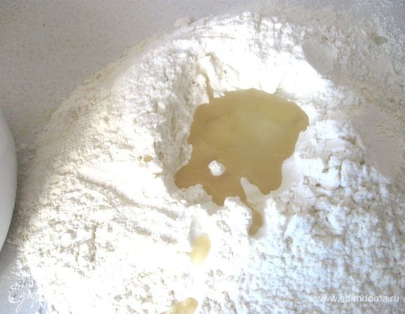 Поставить 350  мл воды в морозилку (количество воды приблизительное, может потребоваться меньше), чтобы она поскорее охладилась. Нам нужна ледяная вода через некоторое время, чтобы добавлять в тесто и в фарш. Муку смешать с солью, просеять. Из половины муки сделать горку с углублением сверху, добавить в углубление растительное масло.