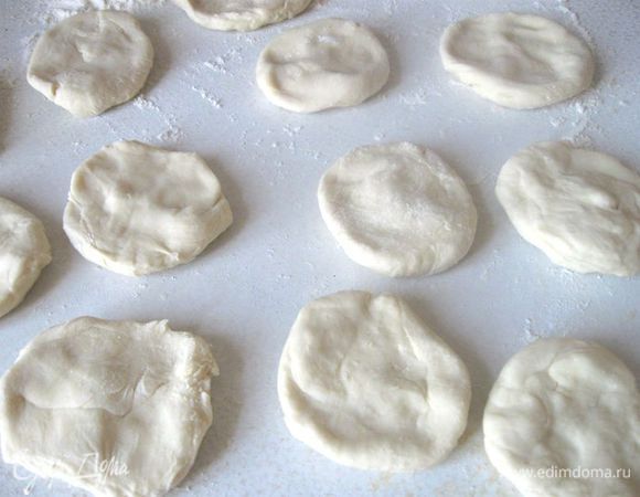Из шара теста отщипывать кусочки и разминать их в небольшие лепешки. Можно скатать колбаску и от нее отрезать кусочки и разминать на рабочей поверхности, присыпанной мукой.