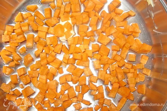 Нарезаем морковь квадратиками. И выкладываем на противень с растительным маслом, в котором будем запекать запеканку.