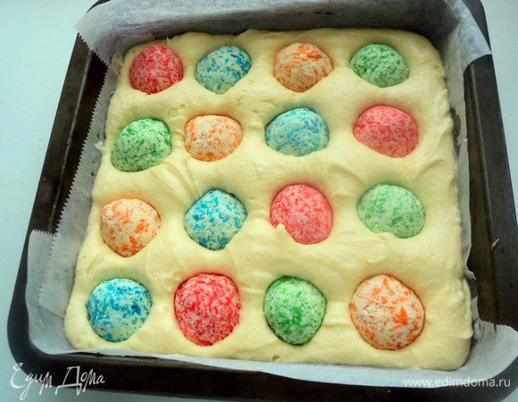 Светлую часть теста вылить в форму, подготовленную аналогичным способом. Выложить разноцветные кокосовые шарики, чередуя их. У меня поместилось по 4 шарика разного цвета. Выпекать при 190 градусах 30-35 минут. Готовый пласт остудить на решетке.