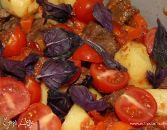 Добавить картофель, черри и листья базилика к мясу, готовить на среднем огне еще 20 минут