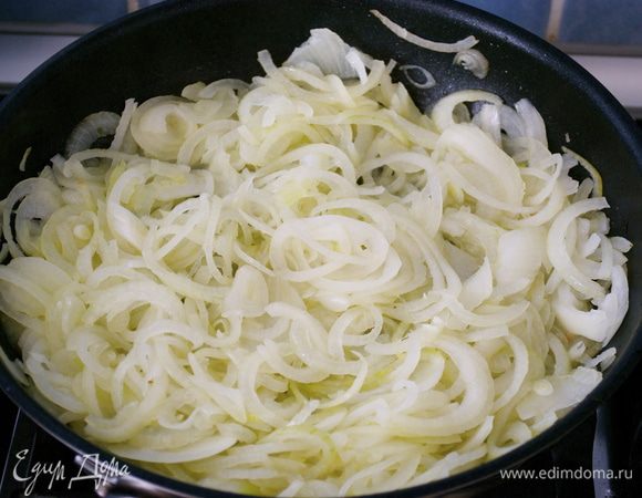 Лук очистить и нарезать тонко. В глубокой сковороде разогреть 4 ст.л. оливкового масла, добавить 1 ст.л. воды и потушить лук, время от времени помешивая. Посолить лук и снять сковороду с огня.