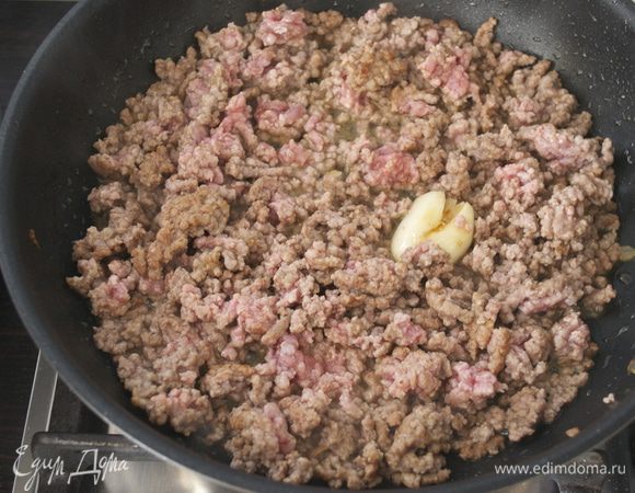 В другой сковороде разогреть 3 ст.л. оливкового масла. Положить раздавленный зубчик чеснока, половину столовой ложки паприки и обжарить несколько секунд. Добавить мясной фарш и обжарить все на среднем огне 5-6 минут. Затем удалить чеснок, посолить, добавить коньяк и продолжить готовить фарш еще 5 минут.
