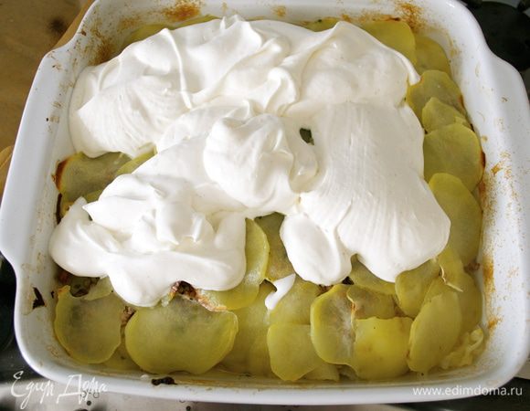 Достать из духовки запеканку, снять фольгу. Выложить сверху получившийся крем и распределить его по всей поверхности запеканки.