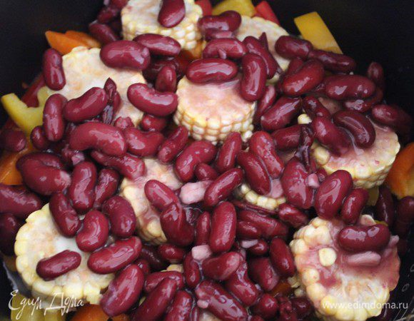 Через 15 минут добавить фасоль, приправить специями, при необходимости добавить еще немного соли по вкусу. Посыпать рубленным чесноком и рубленным перцем чили. Готовить еще 7-10 минут.