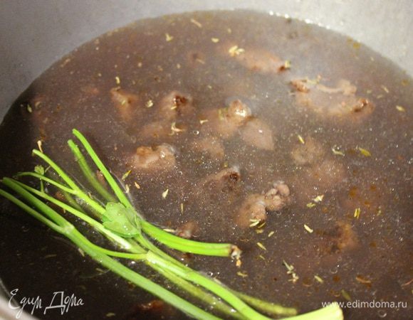 Маринад процедить и добавить в казан, долить бульон, если нужно, т.к. мясо должно быть полностью покрыто жидкостью. Добавить чеснок крупно порезанный, тимьян. Довести до кипения и тушить 2 часа.