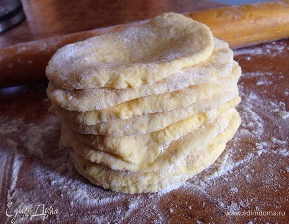 Каждую часть раскатать в небольшую лепёшку на поверхности слегка присыпанной мукой. Лепёшки уложить стопкой. Тесто довольно-таки липкое, поэтому хорошо присыпаете мукой!