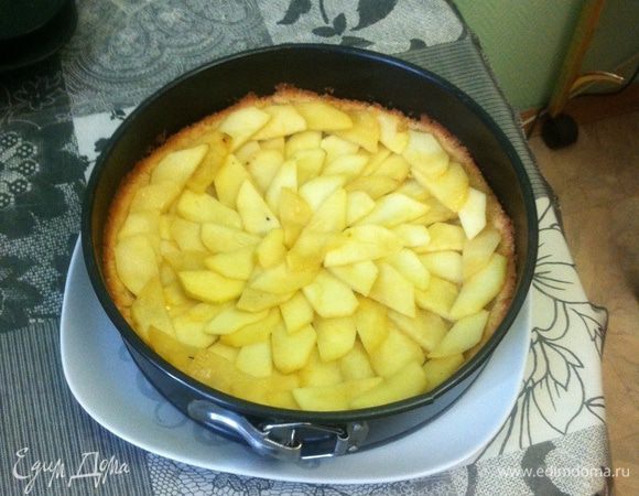 Начинка. Яблоки очистить и нарезать дольками. Сбрызнуть их лимонным соком. Тушить в сковроде на небольшом количестве масла до мягкости. Выложить теплые яблоки в полуготовую основу в форме. 