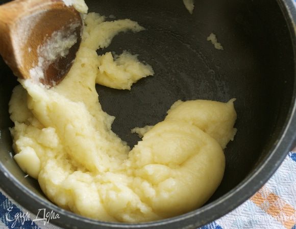 Затем снять кастрюлю с огня и сразу же всыпать в нее всю муку. После этого быстро перемешать смесь до тех пор, пока она не перестанет приставать к стенкам кастрюли. Переложить в миску и дать остыть.