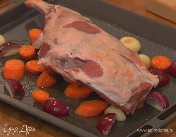 На овощи выложить баранью ногу, посолить и поперчить мясо.