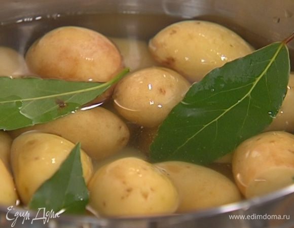 Выложить картофель в кастрюлю, добавить лавровые листья, залить кипятком и варить без добавления соли 7–10 минут до полуготовности, затем воду слить и вынуть лавровые листья.