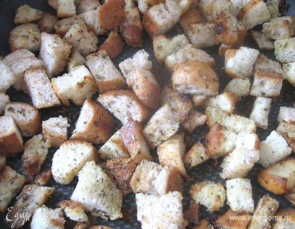 Посыпать сухими травами, перемешать. На  разогретую  сковороду положить кусочек сливочного масла (53 г), туда же отправить кубики хлеба, обжарить до золотистости. Можно их слегка сбрызнуть лимонным соком.