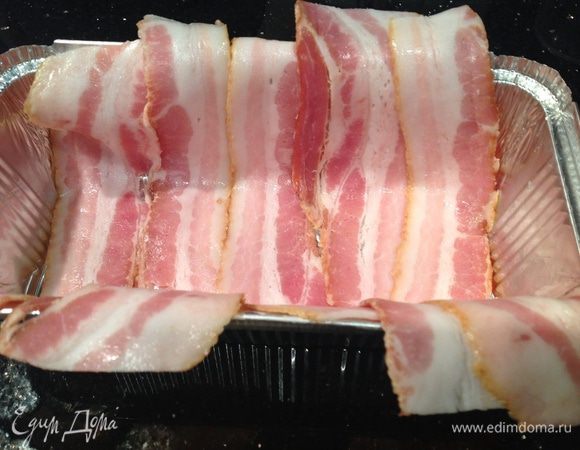В форму для запекания выложить бекон так, чтобы свешивались края.