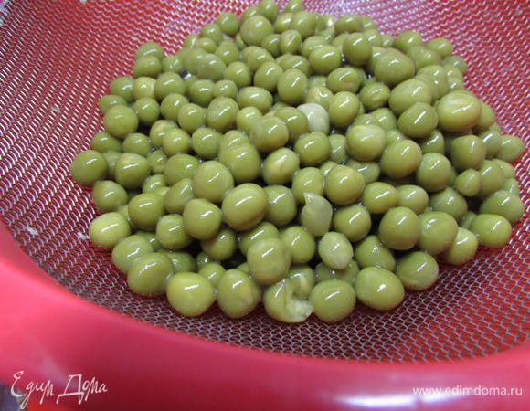 Консервированный горошек откинуть на дуршлаг, дать стечь жидкости.