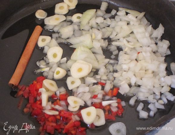 Лук, чеснок, перец и палочку корицы обжарить на разогретом оливковом масле в течение 10 минут на слабом огне.