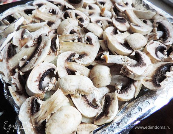 Затем слой нарезанных пластинками помытых шампиньонов. Я выкладываю их сырыми, но они дают много влаги и окорочка получаются во вкусной подливе. Если вы хотите, чтоб влаги в готовом блюде было меньше, предварительно обжарьте грибы до испарения лишней влаги из них. Грибы также немного солим.