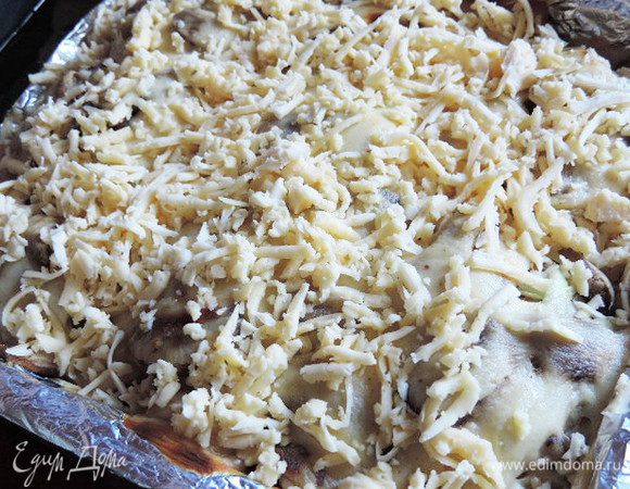Через 40 минут достаем окорочка и посыпаем их тертым сыром. 
