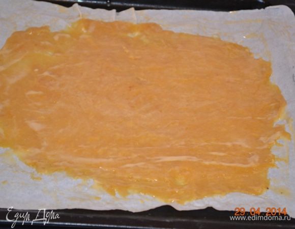 Для удобства можно делать в перчатках, так как тесто горячее. Но я обошлась без них. 
Отщипываем небольшое количество теста и, очень часто смачивая холодной водой руки, как можно тоньше распределяем его по противню, застеленному пергаментом. Слой должен быть максимально тонкий и практически просвечивать.  В духовке оно поднимется в 3-4 раза.  Это делать сложно, тесто горячее, резиновое. Кажется, что его никогда не растянешь максимально тонко. Можно помогать столовой ложкой  смоченной в холодной воде.  В общем фантазируем. 
На фото мой первый корж. Он не максимально тонкий и выпекся тоже толстовато.  Остальные коржи пошли "веселее". Практика)