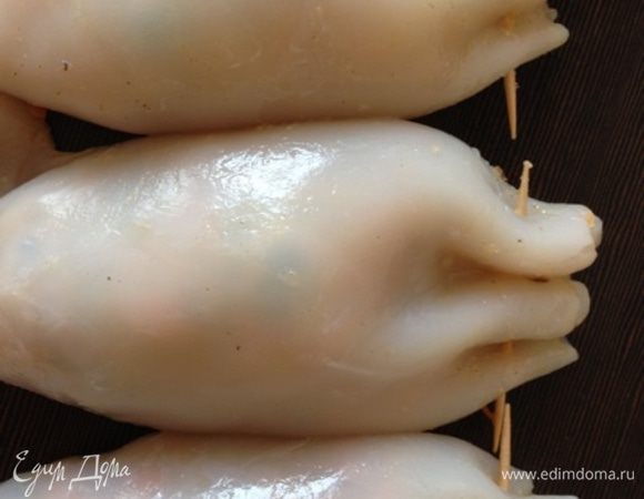 Нафаршируем тушки кальмаров начинкой и скрепим концы зубочисткой.