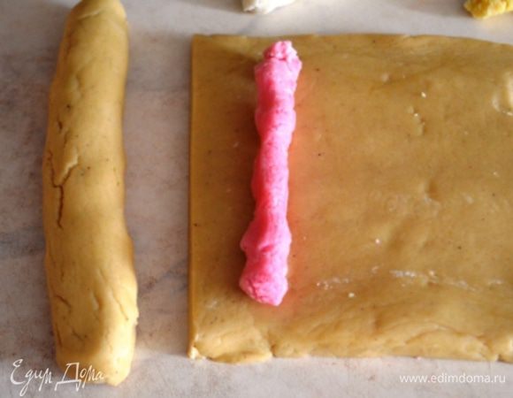 Тесто разрезаем ан 4 кусочка, закатываем каждый кусок марципана в рулет. Края слипляем, чтобы весь марципан был окутан тестом для пряника. 