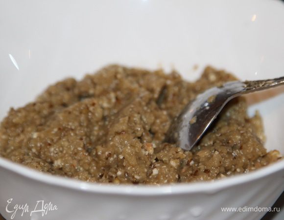 К баклажанам добавить грецкие орехи и измельчить блендером до пюреобразного состояния. Затем выдавить к ним чеснок.