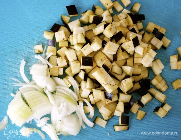 Теперь перейдем к приготовлению соуса Капоната. 
Баклажан нарезать небольшими кубиками. (Кто предпочитает пересыпать нарезанный баклажан солью и дать уйти лишней горечи, может предварительно дать постоять кусочкам баклажана с солью около 1 часа, затем промыть в дуршлаге и высушить на бумажной салфетке. Я обычно пропускаю эту процедуру, мне вкус баклажана нравится таким, какой он есть). Луковицу тонко нарезать. 