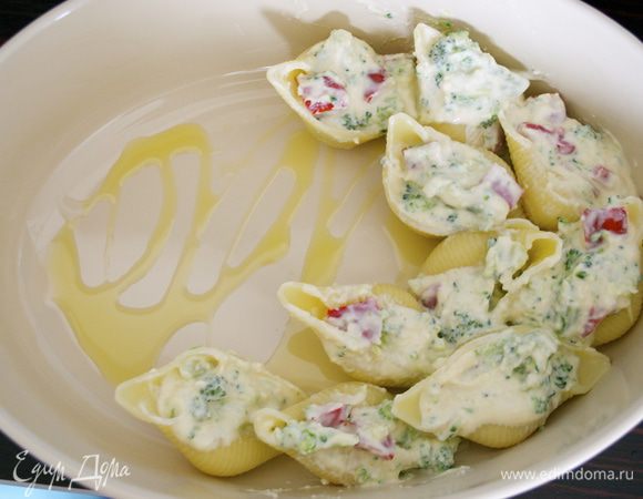 Начинить ракушки сырно-овощной смесью, затем разложить их одним слоем на большом, смазанном маслом огнеупорном блюде. 